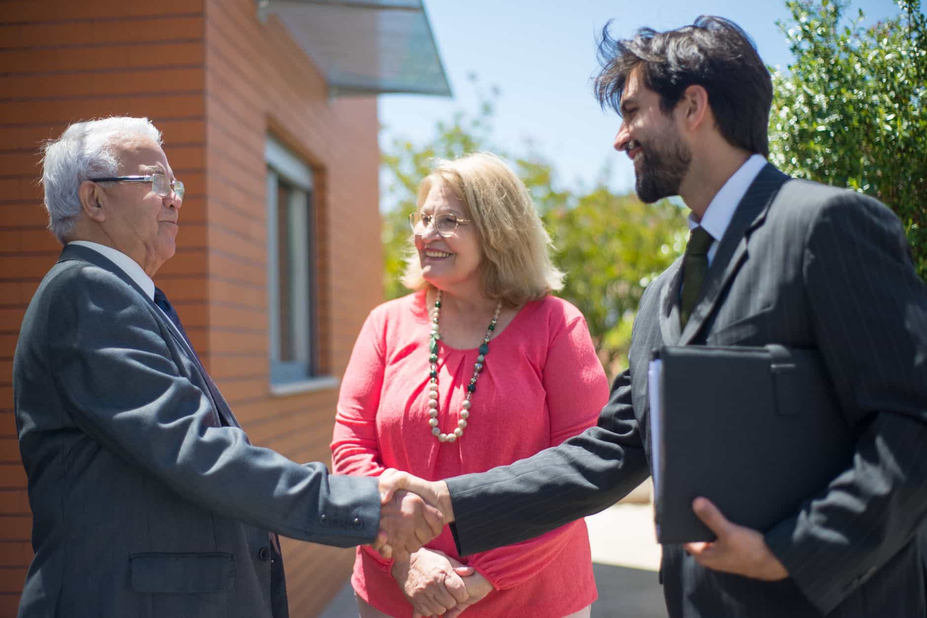 Real estate agent shaking hands with a couple